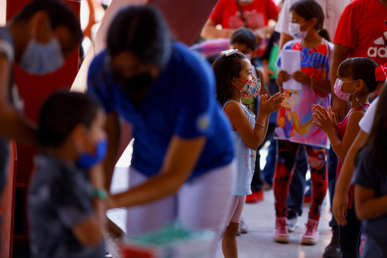 Children wait on line to receive the COVID-19 vaccine.