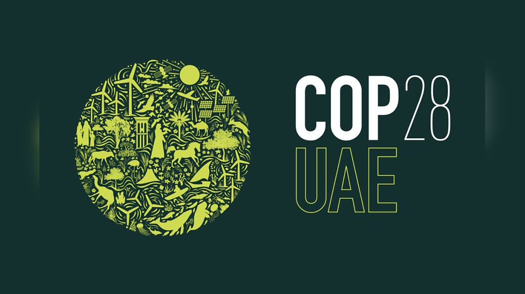 A logo image for the COP28 climate change conference featuring a globe with representations of environment-friendly alternative energy options